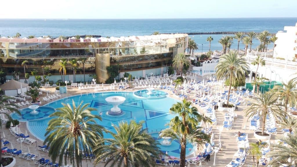 the pool outside the mediterranean palace surrounded by palms. With the ocean in the background