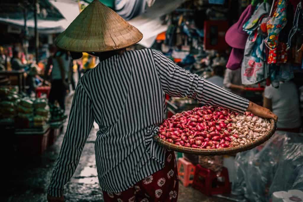 Vietnamese woman carrying fruit in a market